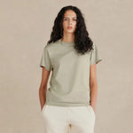 Woman wearing a green t-shirt and white pants against a beige background 7