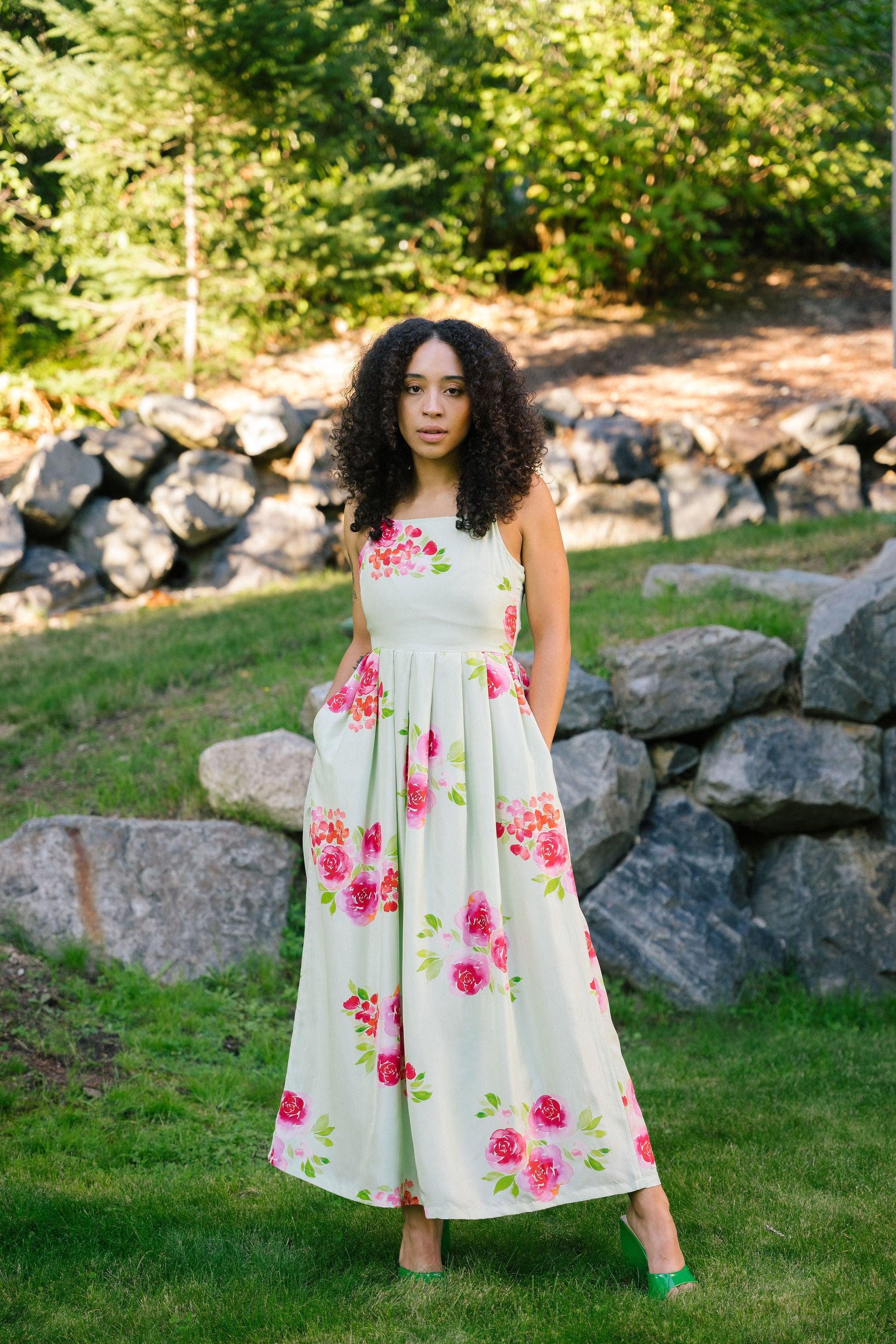 A model wearing Transcend's eliza maxi dress in pistachio green color.The dress is 100% silk habutai with digitized watercolor print